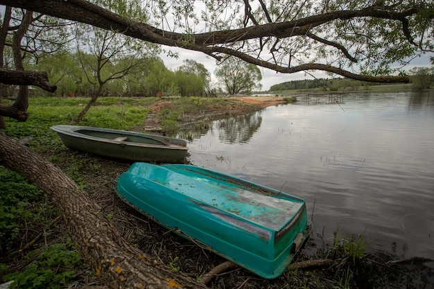 la barca si trova sulle rive del fiume nel villaggio estivo