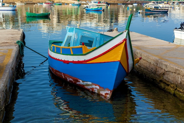 La barca tradizionale a Malta di nome luzzu è ormeggiata tra due lastre di pietra