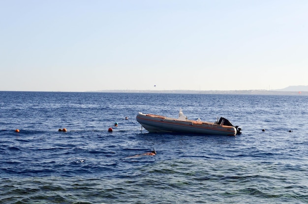 La barca veloce grigia gonfiabile una barca a motore con un motore naviga sul mare blu salato