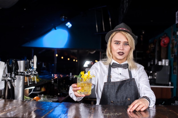 La barista professionista dà il tocco finale a un drink dietro il bar