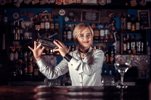 La barista ragazza crea un cocktail nel pub