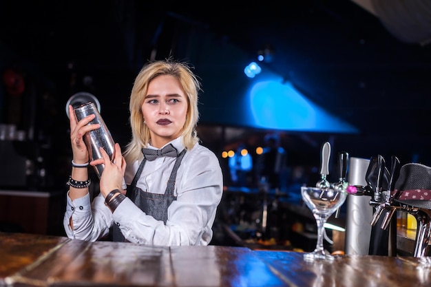 La barista ragazza inventa un cocktail al bar