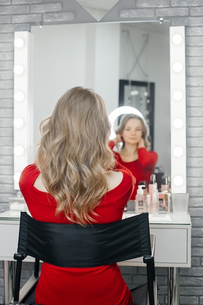 La bella bionda ammira i suoi capelli in un salone di bellezza