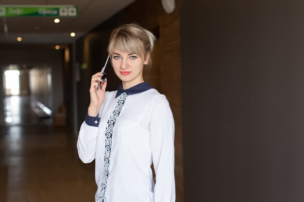 La bella bionda felice parlando al telefono