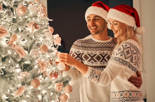 La bella coppia che decora l'albero di Natale