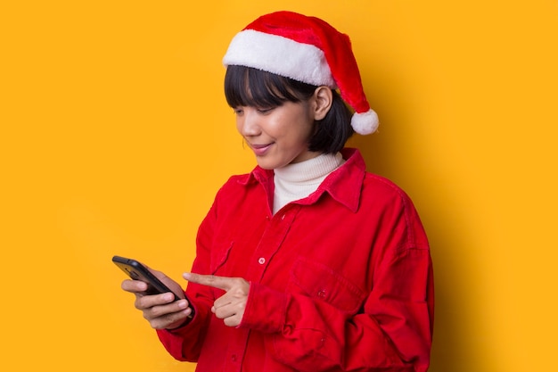 La bella donna asiatica del ritratto porta il cappello di natale della Santa