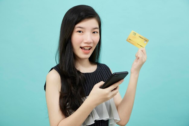 La bella donna asiatica usa smartphone e pagamenti con carta di credito per lo shopping online