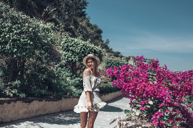 La bella donna bionda emozionante cammina e ammira i paesaggi tropicali all'hotel dell'isola di paradiso a Sanya, Cina.