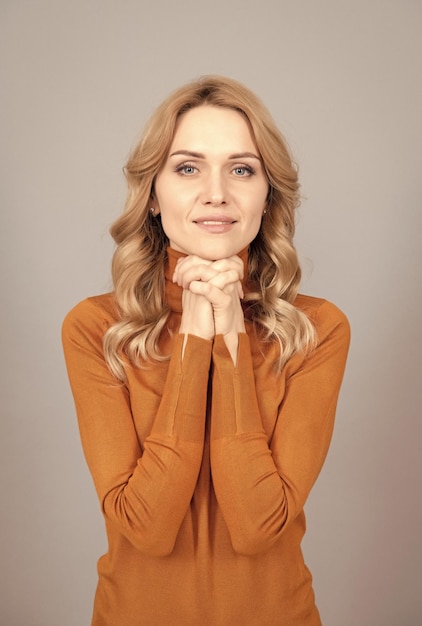 La bella donna bionda ha i capelli ricci si tengono per mano alla moda