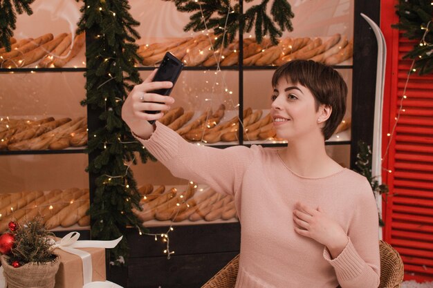 La bella donna castana felice fa un selfie dal telefono