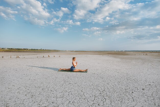 La bella donna che fa yoga per terra all'aperto