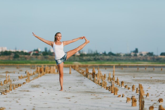 La bella donna che fa yoga per terra all'aperto