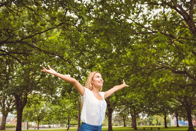 La bella donna con le braccia si è alzata in parco