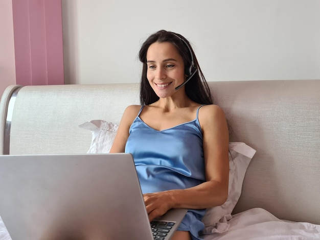 La bella donna con le cuffie ama usare il computer portatile in camera da letto