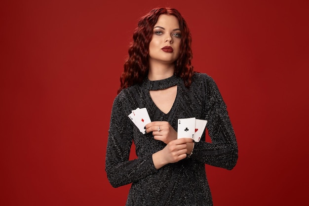 La bella donna dai capelli rossi tiene in mano alcune carte da gioco del casinò