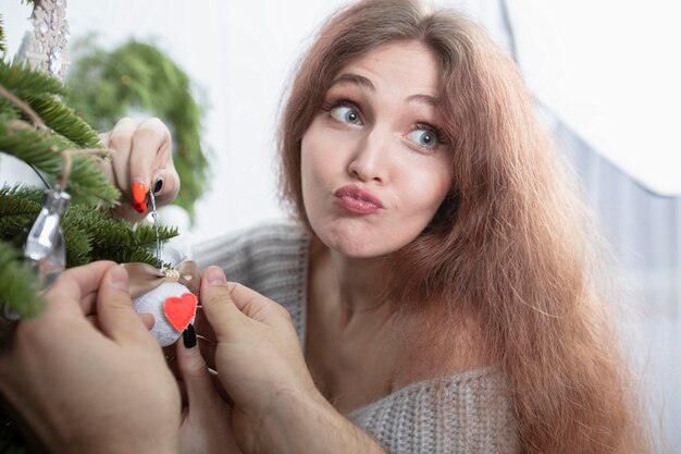 La bella donna decora un albero di Natale