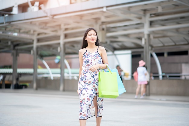 La bella donna è felice con lo shopping in città