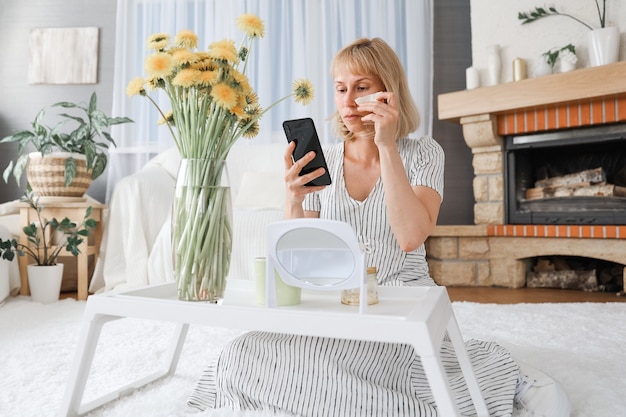 La bella donna fa le procedure di bellezza a casa, usa i cerotti sotto gli occhi. Concetto di stile di vita sanitario