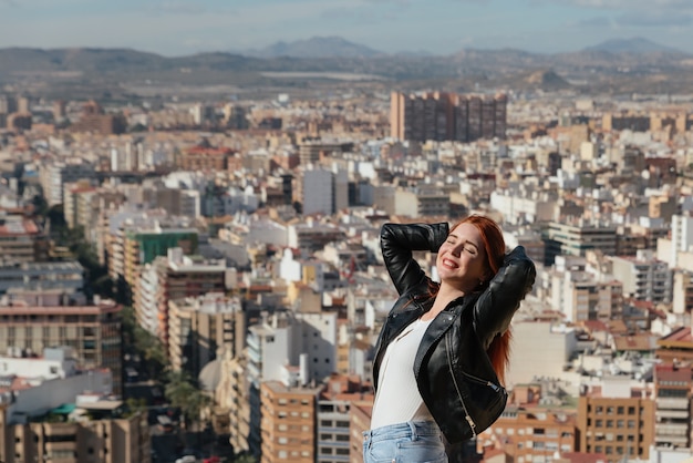 La bella donna felice e giovane gode delle viste della città