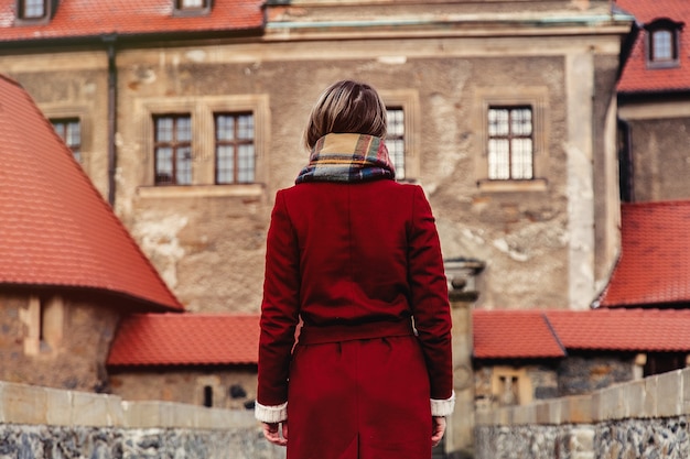 La bella donna in cappotto rosso resta vicino al castello