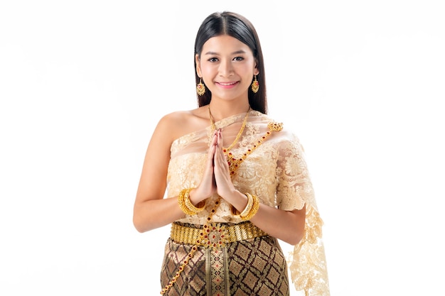 La bella donna paga il rispetto in costume tradizionale nazionale della Tailandia. Isotate su sfondo bianco.