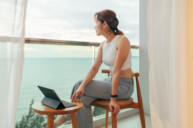 La bella donna si diverte a guardare la vista sul mare dal balcone dell'hotel