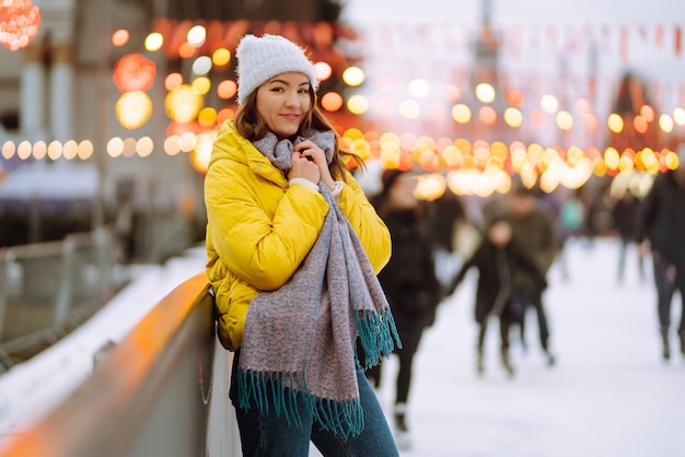 La bella donna si diverte, pattinaggio sul ghiaccio attivo. Concetto di vacanze invernali.