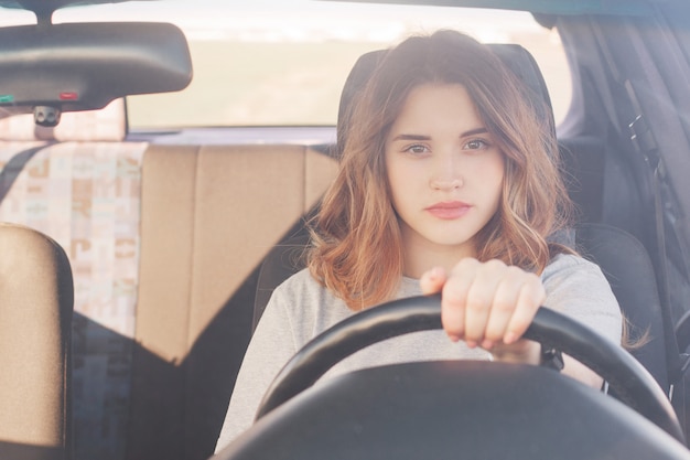 La bella donna sicura di sé in trasporto guida l'automobile