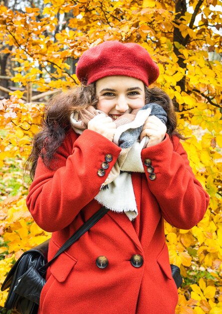 La bella donna sorride nel parco autunnale