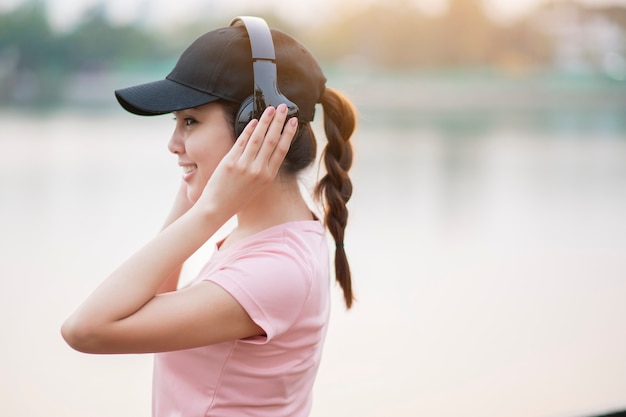 La bella donna sta ascoltando musica nel parco