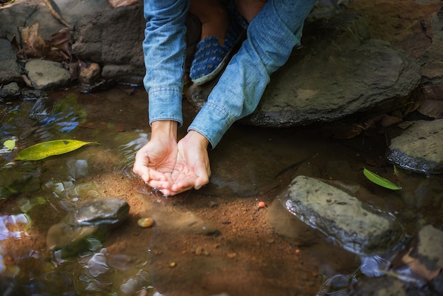 La bella donna sta bevendo l&#39;acqua assetata mentre fa un&#39;escursione per viaggiare