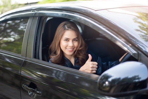 La bella donna sta guidando la sua auto