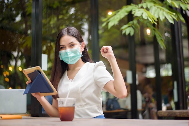 La bella donna sta indossando la maschera nella caffetteria