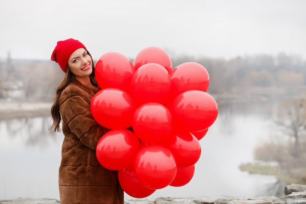 La bella donna tiene un palloncini nelle sue mani