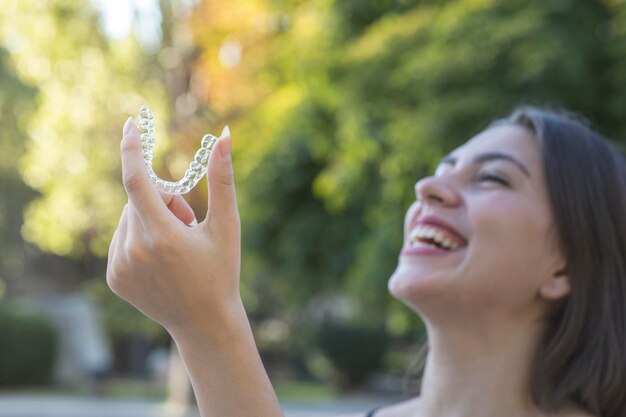 La bella donna turca sorridente sta tenendo un braccialetto invisalign