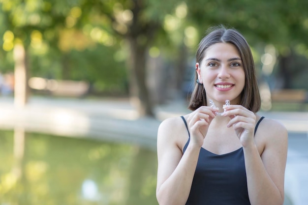 La bella donna turca sorridente sta tenendo un braccialetto invisalign