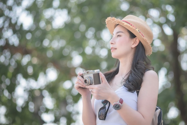 La bella donna turistica sola asiatica gode di di prendere la foto dalla retro macchina fotografica