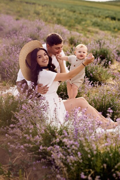 La bella e giovane famiglia in un campo di lavanda trascorre la giornata