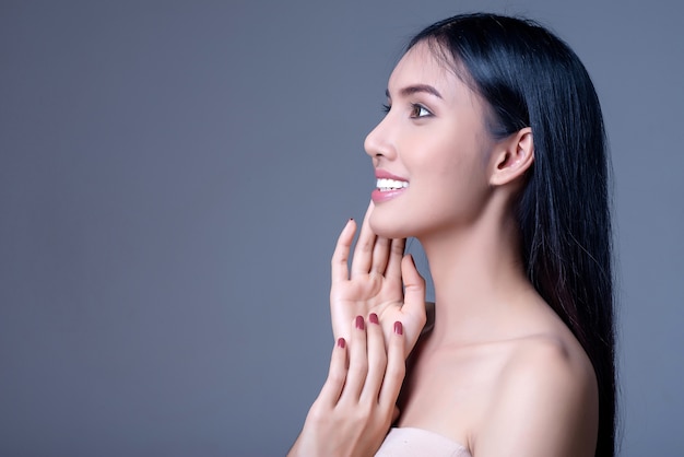 La bella giovane donna con pelle pulita fresca distoglie lo sguardo