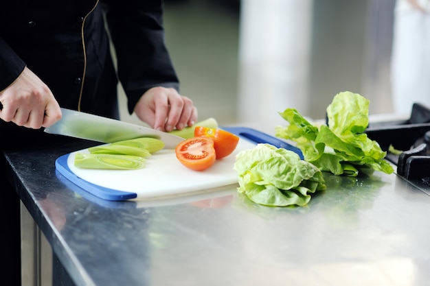 la bella giovane donna del cuoco unico prepara e decora il cibo gustoso in cucina