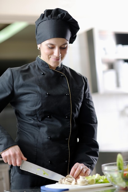 la bella giovane donna del cuoco unico prepara e decora il cibo gustoso in cucina