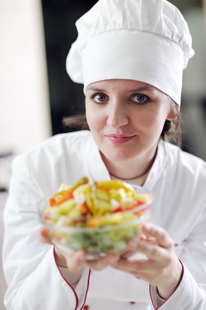 la bella giovane donna del cuoco unico prepara e decora il cibo gustoso in cucina