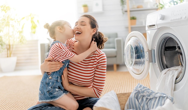 La bella giovane donna e la bambina piccola aiutante si stanno divertendo