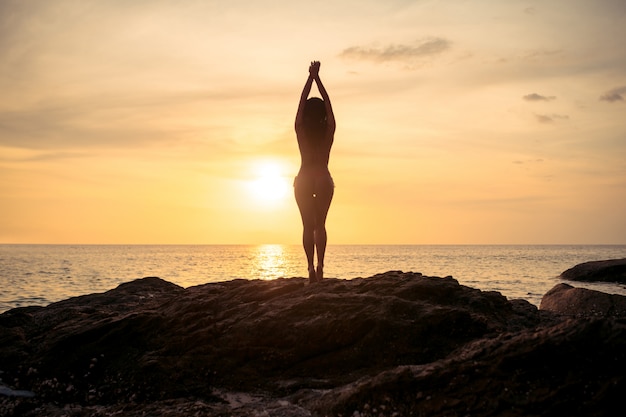 La bella giovane donna ha guardato con gioia il mare e il cielo sul tramonto