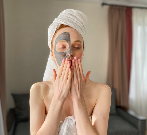 La bella giovane donna ha messo una maschera di argilla