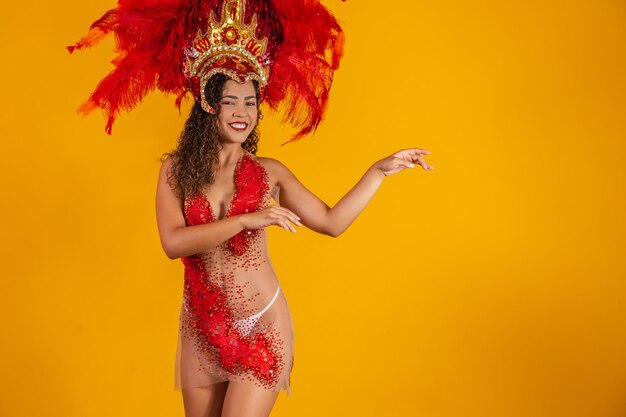 La bella giovane donna in costume speciale della piuma sta ballando allo studio. Samba di carnevale