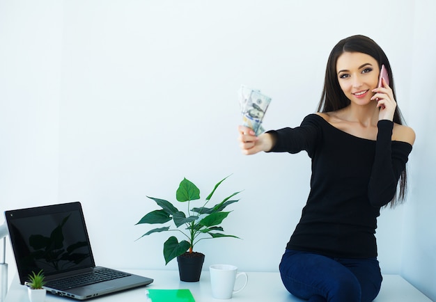 La bella giovane donna lavora al computer.