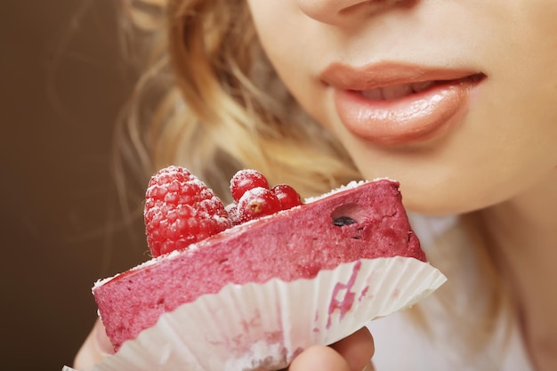 La bella giovane donna sorridente con una torta