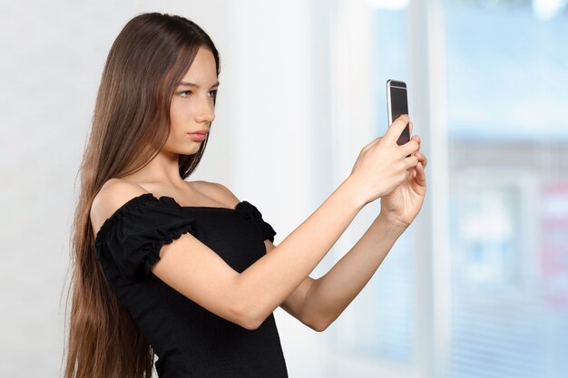 La bella giovane donna sta facendo la foto del selfie con lo smartphone