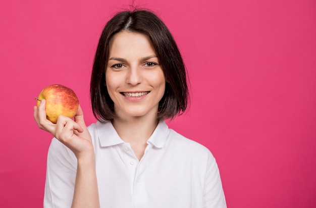 La bella giovane donna tiene in mano una grande mela